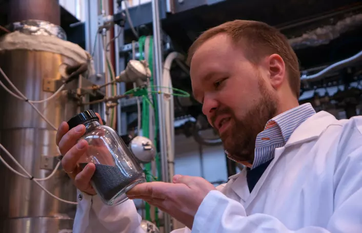 Forsker og fagområdeleder Werner Filtvedt med et glass silisiumkuler fra væskesengreaktoren i bakgrunnen. (Foto: Arnfinn Christensen, forskning.no.)