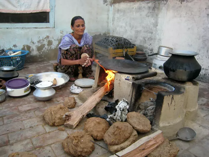 En kvinne i Rorikapura i delstaten Punjab lager det indiske brødet chapati. Hun fyrer med ved og tørket husdyrgjødsel. (Foto: Anna Marie Nicolaysen)