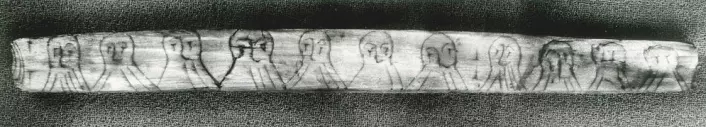 En runepinne fra 1100-tallets Bryggen i Bergen viser at folk lekte seg med skriften. Strekene i skjegget til mennene utgjør et kodet budskap, skrevet med sifferruner. (Foto: Aslak Liestøl/Kulturhistorisk museum, UiO)