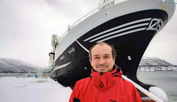 Research scientist Héctor Peña stands in front of purse seiner Vendla during a different survey in 2019.
