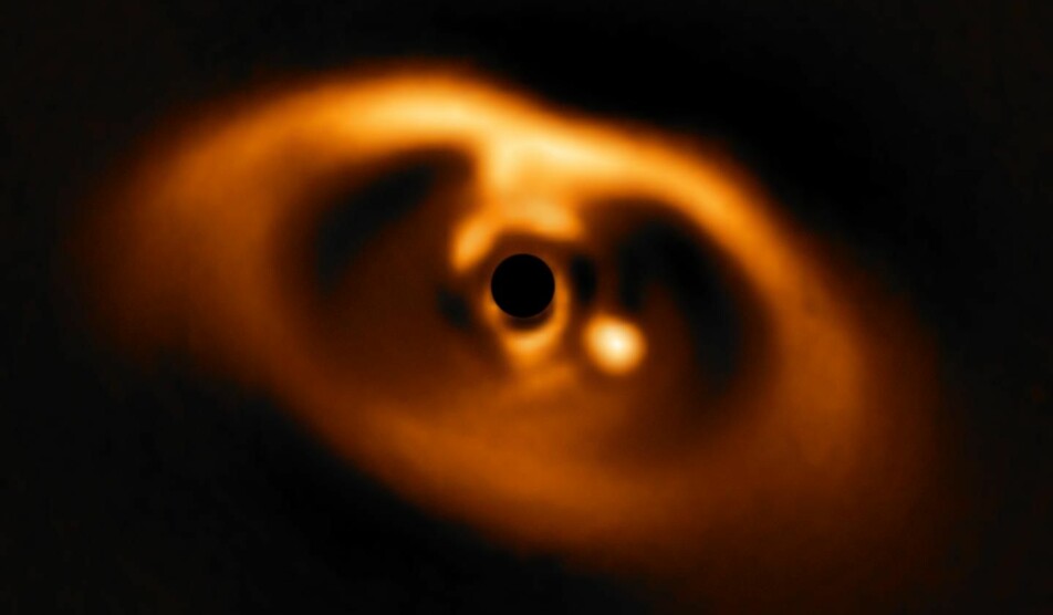 I dette bildet, tatt i 2018, er lyset fra stjernen blokkert bak den svarte sirkelen i midten. Planeten PDS 70b er den lyssterke flekken til høyre for den svarte sirkelen.