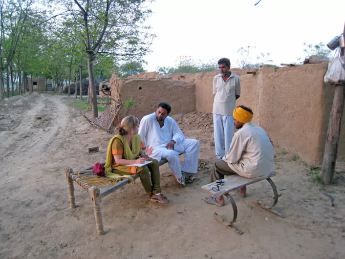 Anna Marie Nicolaysen gjør intervju med en bomullsplukker i Punjab. Bonden og en tolk er også med på bildet. (Foto: Privat)