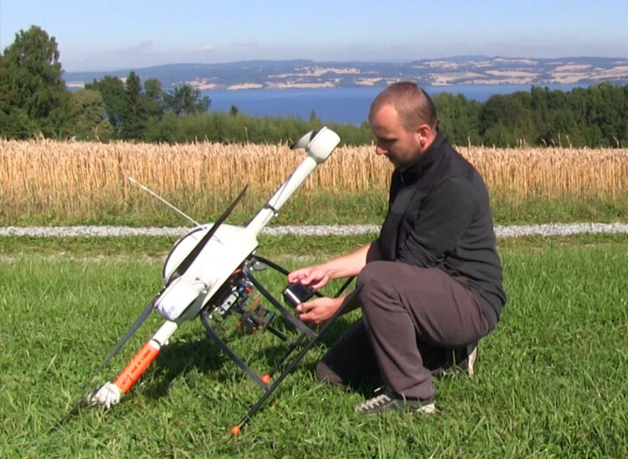 Forsker Krzystof Kusnierek fra Bioforsk Øst gjør robothelikopteret klart for ny fotoferd ved forsøksåkeren på Apelsvoll, Østre Toten. (Foto: Arnfinn Christensen, forskning.no) Forsker Krzystof Kusnierek fra Bioforsk Øst gjør robothelikopteret klart for ny fotoferd ved forsøksåkeren på Apelsvoll, Østre Toten. (Foto: Arnfinn Christensen, forskning.no)