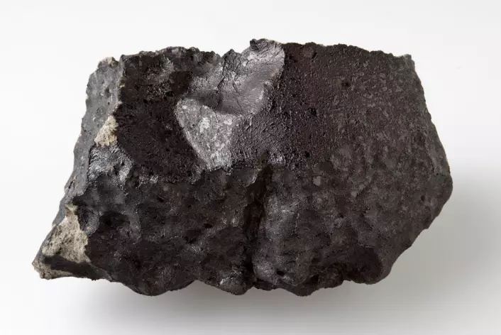 Baksida av den 1,1 kilo tunge steinen er nesten helt dekt av blank, svart smelteskorpe som ble dannet under meteorenes heite ferd igjennom atmosfæren. (Foto: Natural History Museum, London)