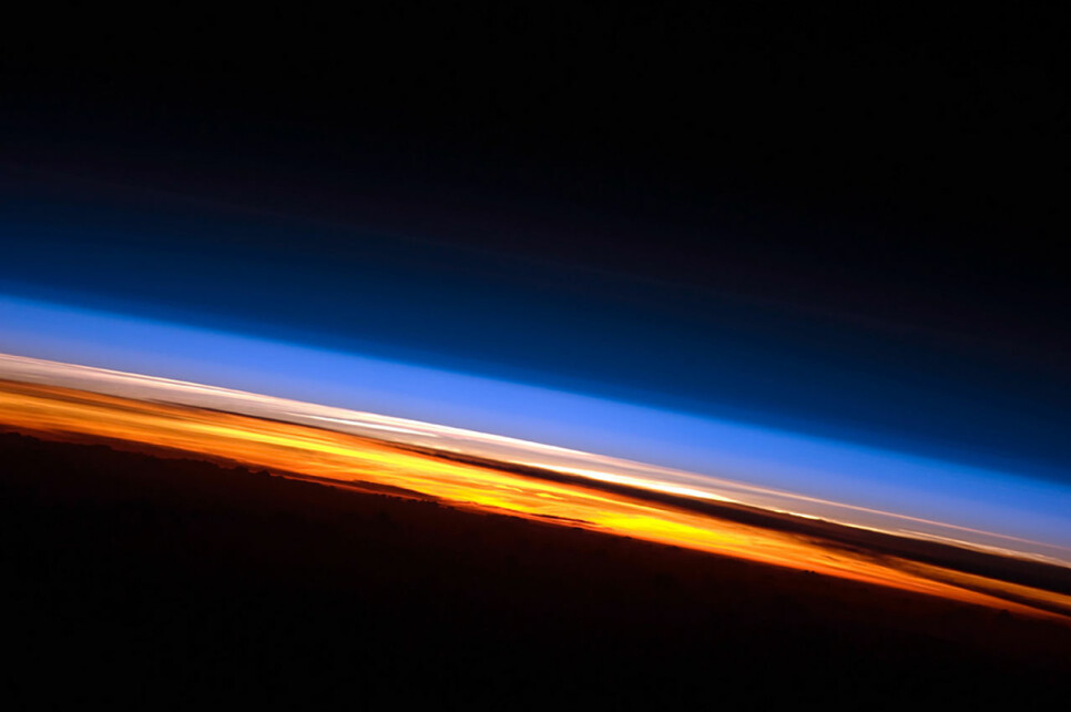 Solnedgang fotografert av en satellitt over Det indiske hav. Her ser du tydelig lagene i atmosfæren. Nederst i oransje og rødt er troposfæren. Over der ligger stratosfæren i rosa og hvitt. Over den forsvinner gradvis resten av atmosfæren (blå) ut i verdensrommet. Avstanden fra jordoverflaten til toppen av stratosfæren er i underkant av 1 prosent av jordas radius.