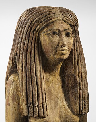 Trestatue av egyptisk kvinne, 1900–1800 f.Kr. Hun har en stor parykk, satt som brede lokker. Ved midtskillen ser vi en liten strek som viser et tørkle under parykken. Trestatue av egyptisk kvinne, 1900–1800 f.Kr. Hun har en stor parykk, satt som brede lokker. Ved midtskillen ser vi en liten strek som viser et tørkle under parykken.