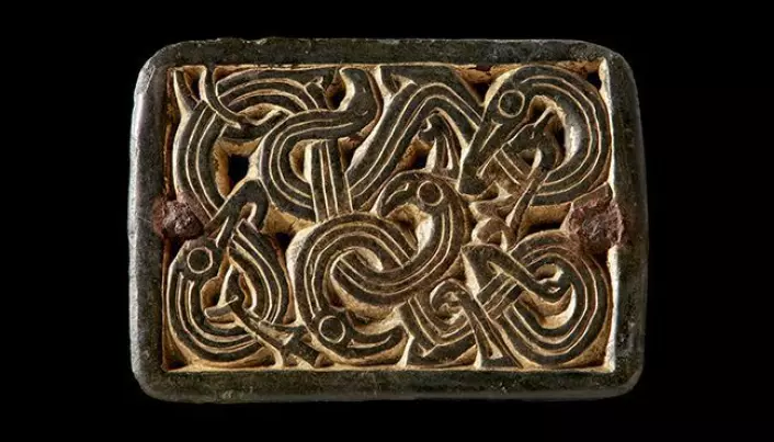 Spenne med slangelignende dyr fra merovingertid (ca. 550-800 e.Kr.). Spennen er laget av kobberlegering og er forgylt med gull. Den har opprinnelig vært festet til seletøy eller et belte med små nagler i hjørnene, men har senere fått en nål montert på baksiden og blitt brukt som spenne, antagelig på en kvinnedrakt.