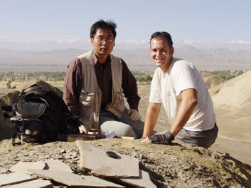 "Paleontologene Hai-lu You (t.v) Matthew Lamanna i nærheten av funnstedet i Changma. Flere fossiler er synlige i forgrunnen. Photo: Kenneth J. Lacovara/Drexel University." "Paleontologene Hai-lu You (t.v) Matthew Lamanna i nærheten av funnstedet i Changma. Flere fossiler er synlige i forgrunnen. Photo: Kenneth J. Lacovara/Drexel University."