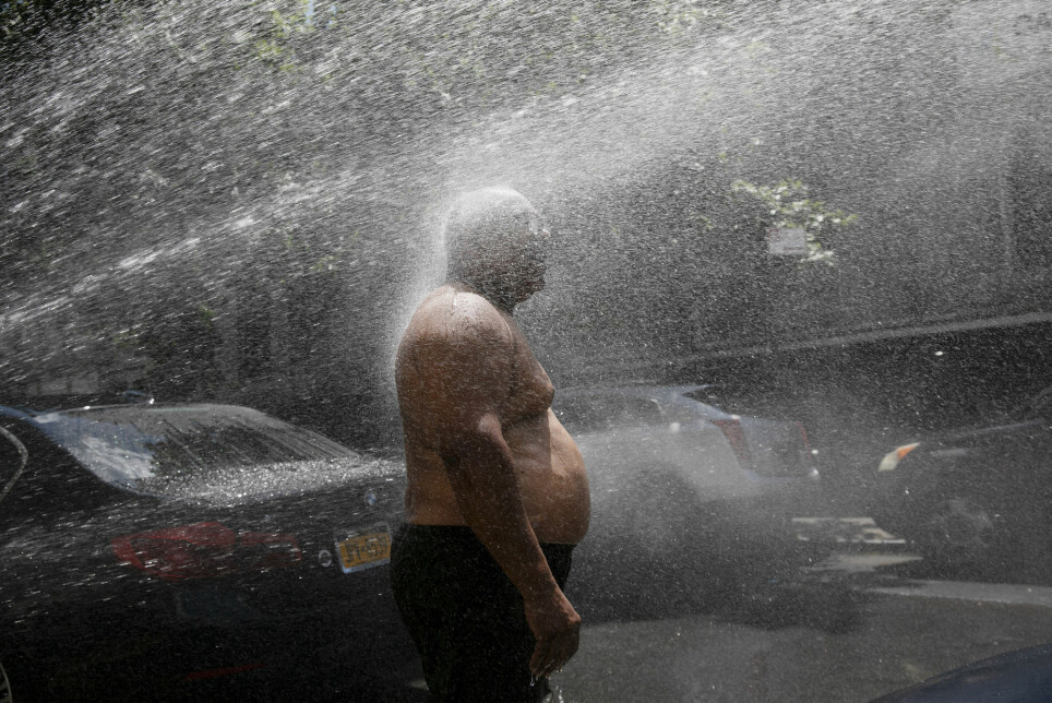 Denne mannen kjølte seg ned med vann fra en brannhydrant under en hetebølge i New York i fjor. Mange varmerelaterte dødsfall kommer som en følge av global oppvarming.
