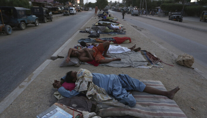 Arbeidere hviler på bakken i Karachi i Pakistan 18. mai da deler av Pakistan opplevde en hetebølge. Arbeidere hviler på bakken i Karachi i Pakistan 18. mai da deler av Pakistan opplevde en hetebølge.