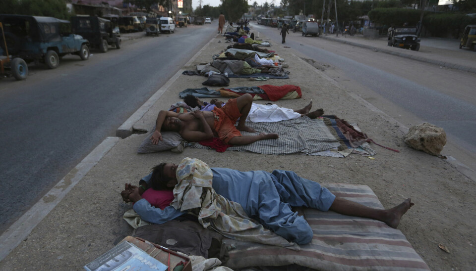 Arbeidere hviler på bakken i Karachi i Pakistan 18. mai da deler av Pakistan opplevde en hetebølge.