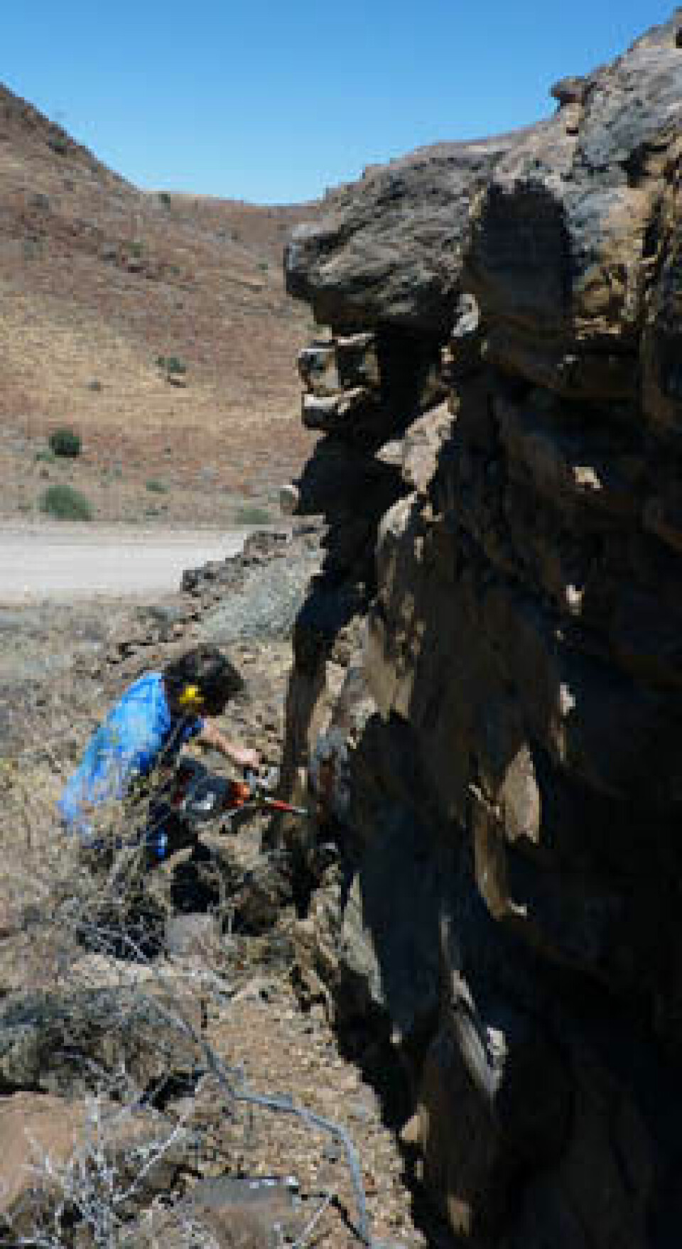 Morgan Ganerød fra NGU borer seg inn i bergveggen for å ta prøver.