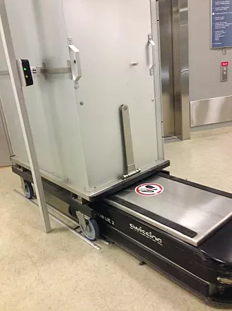 St. Olavs Hospital was the first hospital in Scandinavia to adopt the use of simple transport robots in the hospital buildings. The photo shows one of the robots loading a cart.