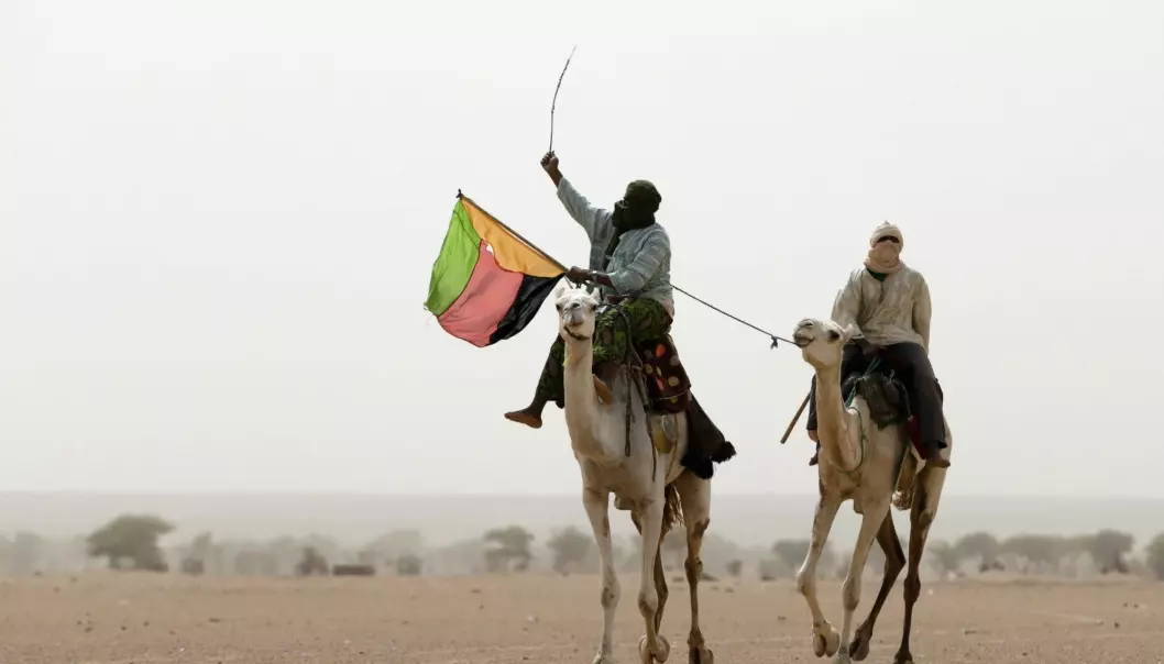 Azawad ble utropt som egen stat i den nordlige delen av Mali i 2013 – her holder en støttespiller flagget til staten under en demonstrasjon. Lokale ledere sørget for forskjeller i styringen fra by til by, blant annet i om de mest voldelige straffene ble praktisert.
