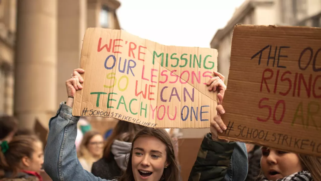 Elever i klimastreik krevde handling for miljøet. Her holder en ung person en plakat om at foreldre og lærere kan lære noe av dem