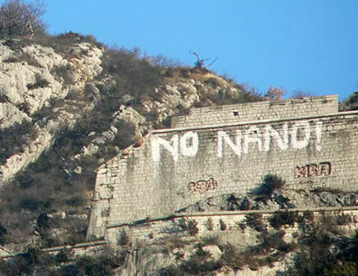 Grafitti på en fjellvegg i Grenoble i Frankrike som protest mot planene om et laboratorium for nanovitenskap i 2006. (Foto: David Monniaux, Wikimedia Commons, se lisens)