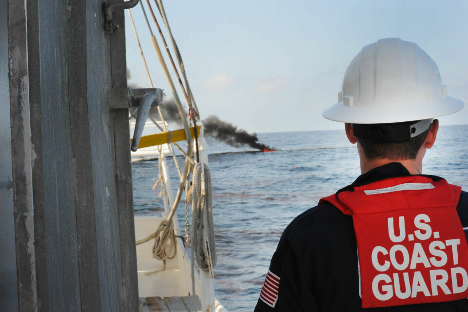 'En amerikansk kystvaktsoldat følger med på kontrollert brenning av olje i Mexicogolfen. (Foto: US Navy ved Petty Officer 1st Class Jeffery Tilghman Williams)'