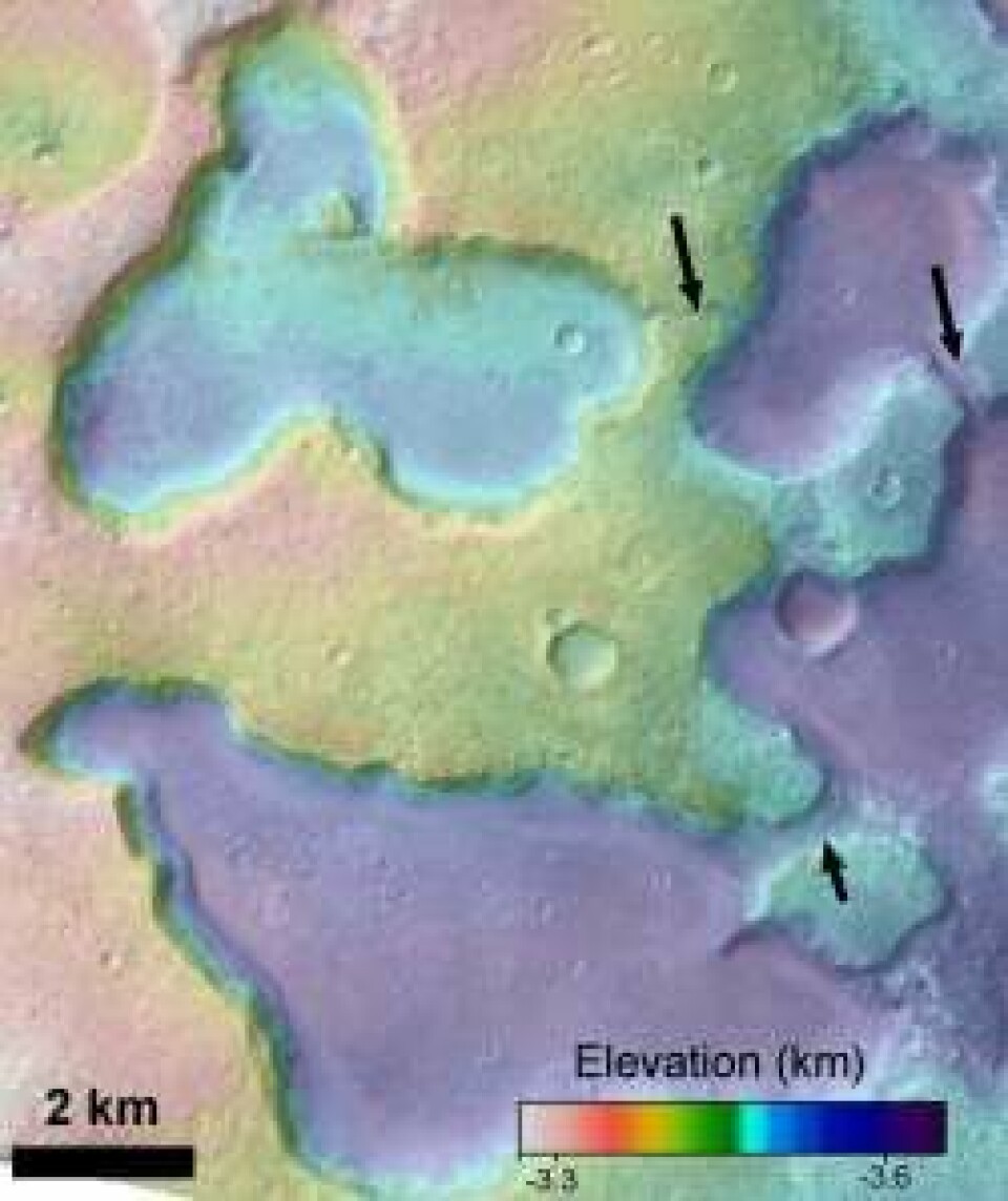 På dette bildet, med kunstige farger som angir høyden på Mars-overflaten, er tre kanaler mellom de gamle sjøene markert med piler. (Foto: NASA)