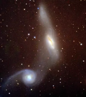 To galakser som holder på å kollidere stjeler materiale fra hverandre. Denne prosessen aktiverer galaksenes kjerner. (Foto: NASA)