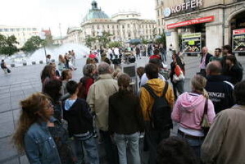 "Mange ble svært interessert i å få interagere med ACE (skimtes i bakgrunnen) på dens ferd gjennom München. (Foto: Cluster of excellence CoTeSys - Cognition for Technical Systems)" "Mange ble svært interessert i å få interagere med ACE (skimtes i bakgrunnen) på dens ferd gjennom München. (Foto: Cluster of excellence CoTeSys - Cognition for Technical Systems)"
