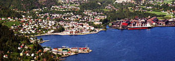 Industribyen Sauda sett fra fjorden. Åbøbyen hageby ligger midt i bildet ned mot fabrikken. (Foto: Geir Høiland) Industribyen Sauda sett fra fjorden. Åbøbyen hageby ligger midt i bildet ned mot fabrikken. (Foto: Geir Høiland)