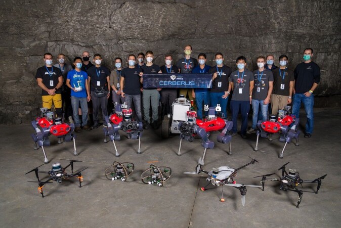 Team CERBERUS assembled with all the robots deployed in the competition. Team CERBERUS assembled with all the robots deployed in the competition.