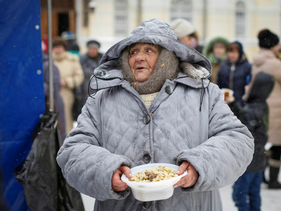 En kvinne holder fram gratismåltidet hun har fått utdelt fra en organisasjon som hjelper hjemløse russere i byen Stavropol.
