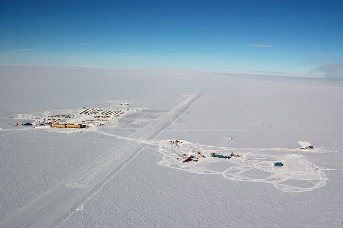 Luftfoto av Scott/Amundsen-basen til høyre og IceCube til venstre, med rullebanen i midten. (Foto: Forest Banks, NSF) Luftfoto av Scott/Amundsen-basen til høyre og IceCube til venstre, med rullebanen i midten. (Foto: Forest Banks, NSF)