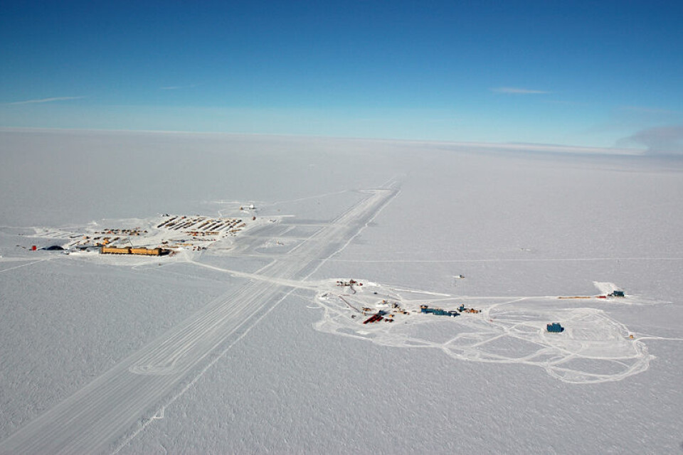 Luftfoto av Scott/Amundsen-basen til høyre og IceCube til venstre, med rullebanen i midten. (Foto: Forest Banks, NSF)