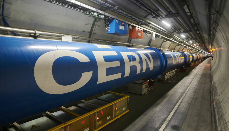 LHC ligger i en 27 kilometer lang tunnel. Maskinen består av sterke magneter som er med på å akselerere stråler av partikler opp i nesten lystes hastighet.