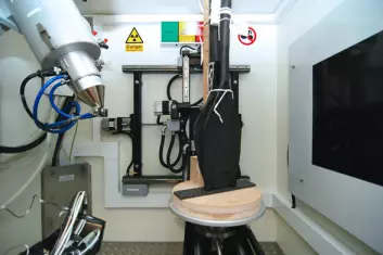 NGIs CT-skanner inneholder et wolframelement og en metallplate (t.v.) som sender en røntgenstråle gjennom materialet som skal undersøkes, i dette tilfellet to spader fra Oseberg-haugen. Platen på veggen til høyre registrerer røntgenstrålene etter at de har passert gjennom prøven. (Foto: NGI)
