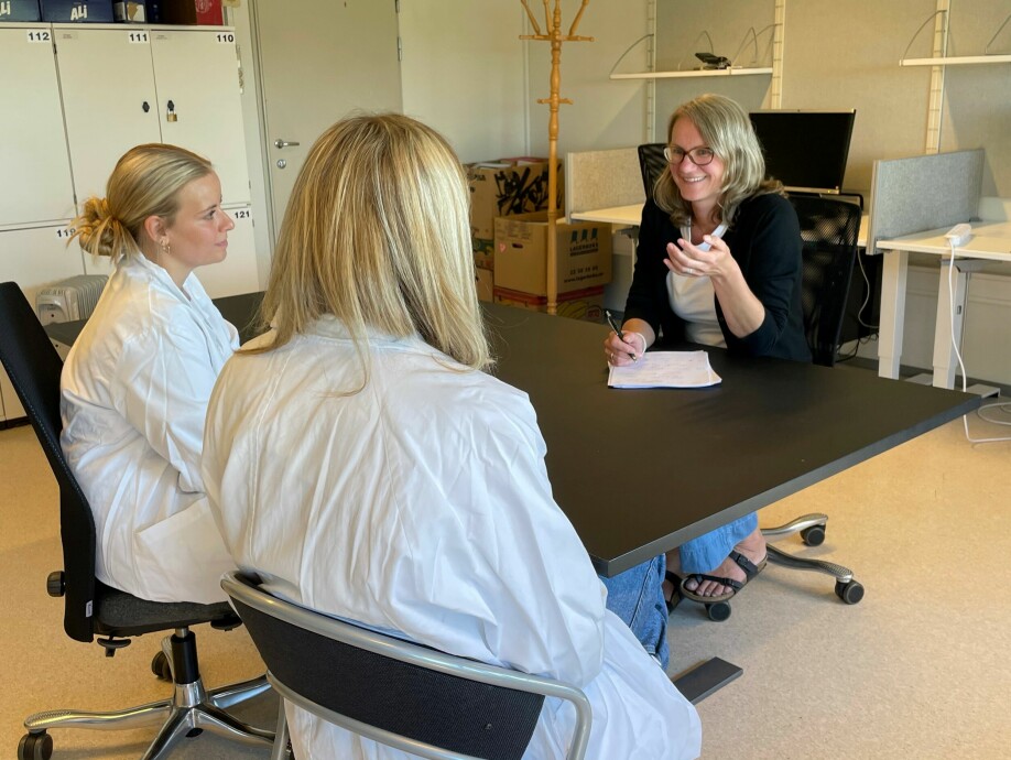 Hanne Cathrine Lie i sort diskuterer pasientkommunikasjon med medisinstudent Maria Gullestad Binder og vitenskapelig assistent Jannicke Kirkøen.