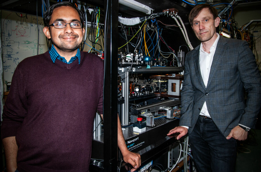 Niels Kjærgaard (til høyre) og Amita Deb (til venstre) foran sitt kompliserte forsøksutstyr. De to fysikerne fra University of Otago på New Zealand har publisert forskningen sin i selskap med noen av verdens mest anerkjente fysikere.