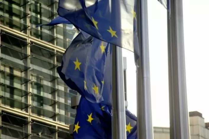 Flagg foran EU-kommisjonens bygg i Brussel. Norske forskningsinstitutter har fått krav om å betale tilbake millionbeløp etter forskningssamarbeid med EU.