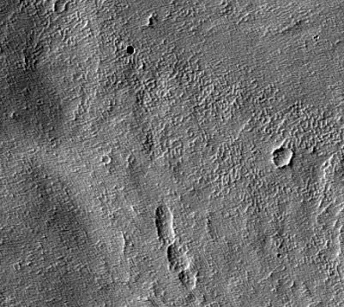 Øverst til venstre sees et lavarør, en munning på en gammel vulkan som kan romme en hule der framtidige marskolonister kan søke tilflukt. (Foto: HiRISE-sonden, NASA)