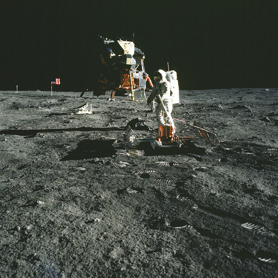 'Her setter Buzz Aldrin opp det seismiske måleutstyret. Litt bak han til venstre står laserreflektoren, og i bakgrunnen kan man også skimte det amerikanske flagget og TV- kameraet som ble brukt til direkteoverføringen av månelandingen. (Foto: NASA)'