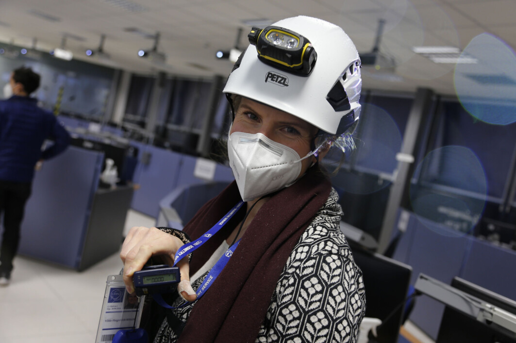 Null stråling! Vilde Flognfeldt Rieker, stipendiat ved Universitetet i Oslo, viser fram dosimeteret som har vært med på runden nede i ATLAS. Alle som skal ned til LHC og detektorene må ha med seg en slik liten boks, som måler stråling i miljøet. Når den digre maskinen er i drift, oppstår det farlig stråling nede i tunnelen. Dette skal ikke skje mens LHC står og folk arbeider på detektorene, men dosimeteret må likevel med for sikkerhets skyld. Null stråling! Vilde Flognfeldt Rieker, stipendiat ved Universitetet i Oslo, viser fram dosimeteret som har vært med på runden nede i ATLAS. Alle som skal ned til LHC og detektorene må ha med seg en slik liten boks, som måler stråling i miljøet. Når den digre maskinen er i drift, oppstår det farlig stråling nede i tunnelen. Dette skal ikke skje mens LHC står og folk arbeider på detektorene, men dosimeteret må likevel med for sikkerhets skyld.
