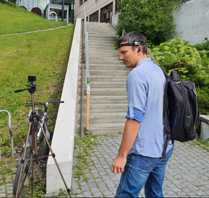 Forsker og akustiker Tron Vedul Tronstad sjekker utstyret som skal brukes før joggeøkta i trappa.
