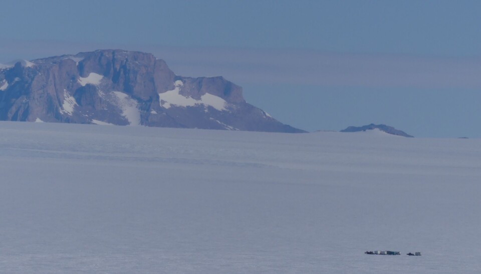 Transport av last fra iskanten mot Troll, vogntogene blir små i det mektige fjell- og islandskapet i Dronning Maud Land.