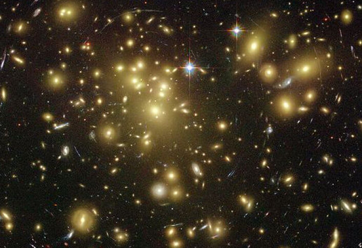 Hvordan ta bilde av mørk materie? Store masser bøyer lyset. Her kikker Hubbleteleskopet igjennom en enorm hop av galakser, mot galakser som ligger bakenfor. Gravitasjonen fra galaksehopen bøyer lyset slik at bildet av galaksene bak blir underlig forstyrret. Hvor sterke slike forstyrrelser blir, kan si en del om hvor mye materie som finnes i galaksehopen. Det er blant annet slike beregninger som hinter om at det må finnes mye mer masse i galaksene enn vi kan se. (Foto: NASA/Hubble Space Telescope) Hvordan ta bilde av mørk materie? Store masser bøyer lyset. Her kikker Hubbleteleskopet igjennom en enorm hop av galakser, mot galakser som ligger bakenfor. Gravitasjonen fra galaksehopen bøyer lyset slik at bildet av galaksene bak blir underlig forstyrret. Hvor sterke slike forstyrrelser blir, kan si en del om hvor mye materie som finnes i galaksehopen. Det er blant annet slike beregninger som hinter om at det må finnes mye mer masse i galaksene enn vi kan se. (Foto: NASA/Hubble Space Telescope)