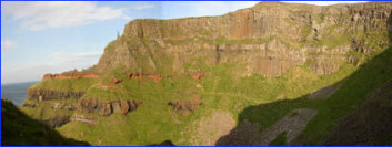 "Landskapet ved Gigant's Causeway i Nord-Irland ble dannet av flere vulkanske utbrudd for over 60 milloner år siden. Tykke lag med lava ble avsatt. Lagrekken viser også at det har vært roligere tider. Det røde laget er lateritt, et jordsmonn som er utviklet i toppen av basalten. Over dette har det kommet flere nye lag med basalt etter hvert som vulkanismen blusset opp igjen." "Landskapet ved Gigant's Causeway i Nord-Irland ble dannet av flere vulkanske utbrudd for over 60 milloner år siden. Tykke lag med lava ble avsatt. Lagrekken viser også at det har vært roligere tider. Det røde laget er lateritt, et jordsmonn som er utviklet i toppen av basalten. Over dette har det kommet flere nye lag med basalt etter hvert som vulkanismen blusset opp igjen."
