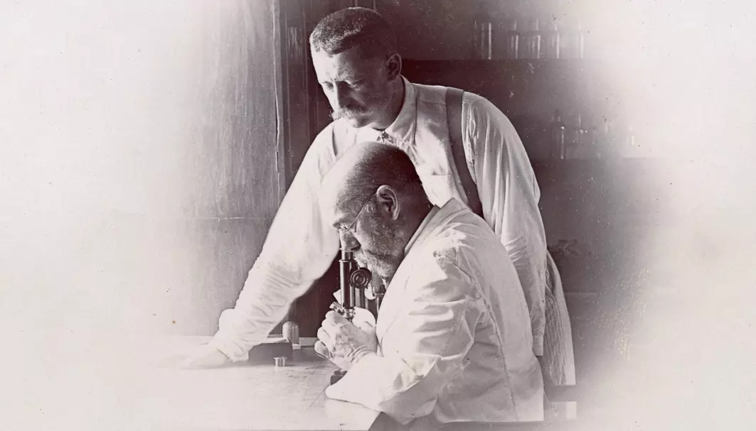 Robert Koch (ved mikroskopet) og Richard Pfeiffer var to av forskerne som for 130 år siden lette etter årsaken til datidens pandemi. Koch skulle senere gjøre viktige oppdagelser rundt mikrobene som forårsaker tuberkulose, kolera og malaria. Pfeiffer trodde han oppdaget influensabasillen bak pandemien. Først i 1933 forsto man at influensa er en virussykdom. Pfeiffer gjorde andre oppdagelser som ble viktigere.