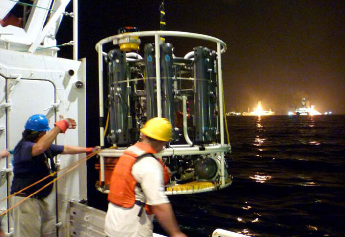 Måleutstyr senkes ned i vannet fra forskningsskipet R/V Endeavor. Massespektrometeret TETHYS, som var svært viktig for å måle nivået av olje i vannet, er synlig nede til høyre på rammen til rosetten som skal senkes. Rosetten har i tillegg 12 flasker for vannprøver. (Foto: C. McIntyre, Woods Hole Oceanographic Institution) Måleutstyr senkes ned i vannet fra forskningsskipet R/V Endeavor. Massespektrometeret TETHYS, som var svært viktig for å måle nivået av olje i vannet, er synlig nede til høyre på rammen til rosetten som skal senkes. Rosetten har i tillegg 12 flasker for vannprøver. (Foto: C. McIntyre, Woods Hole Oceanographic Institution)