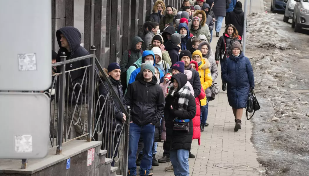 Folk står i kø utenfor en minibank i St. Petersburg for å ta ut pengene sine i dollar og euro 25. februar i år. Siden invasjonen har den russiske rubelen rast i verdi.