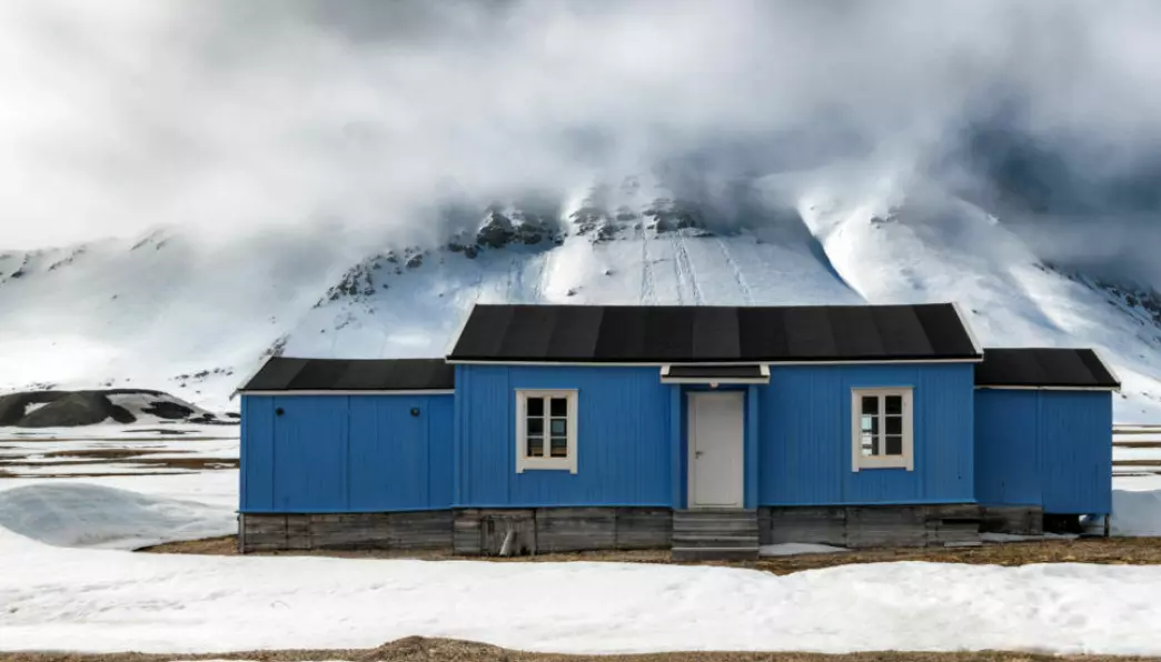 Old, blue, and threatened by climate change. Timber foundations of buildings and structures are affected by rot decay and melting permafrost at Svalbard.