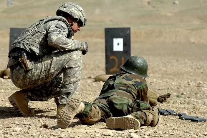 An American staff sergeant trains an Afghan soldier.