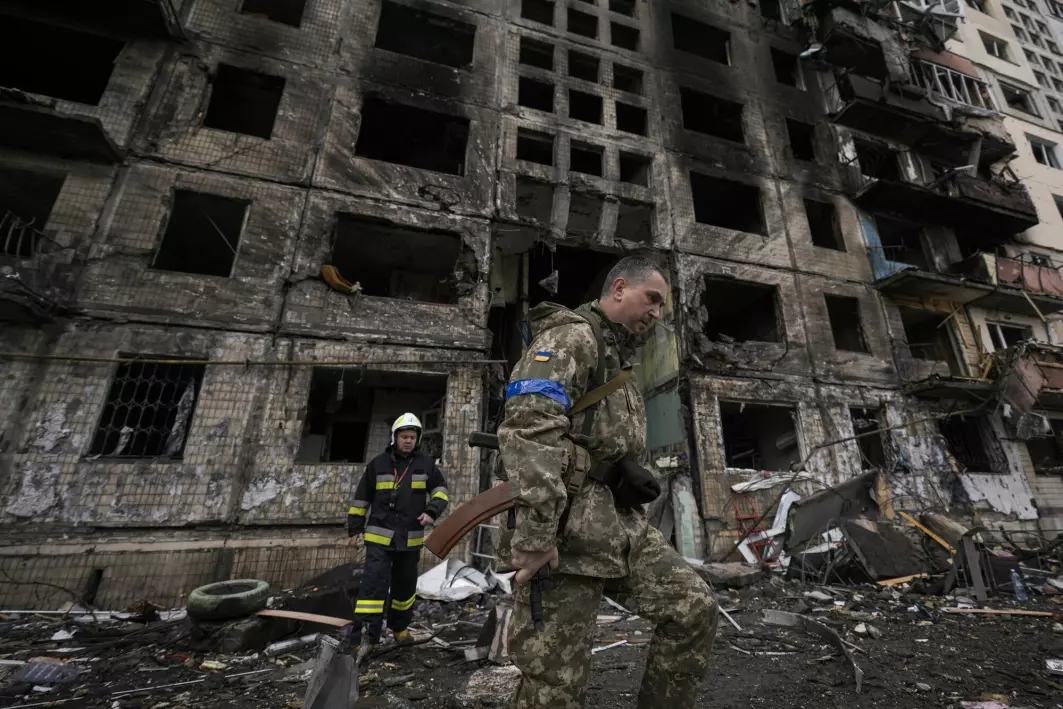 Soldater og brannmannskap gjør søk i en ødelaagt bygning etter bombeangrep i Kyiv mandag 14. mars.