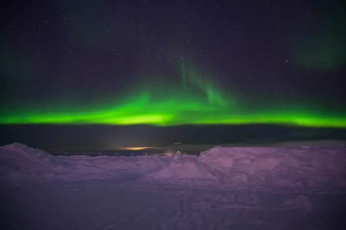 At night, Northern Lights fill the sky.