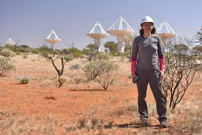 Her ser du en av forskerne foran ASKAP radio telescope i Australia. Alle antennene i bakgrunnen er en del av teleskopet.