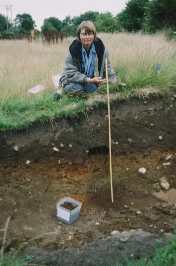 Botaniker Eli-Christine Soltvedt sitter ved et felt for arkeologisk utgraving. (Foto: Terje Tveit)
